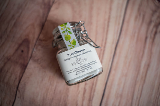 Small glass jar labeled 'Tooth Powder' on a wooden surface