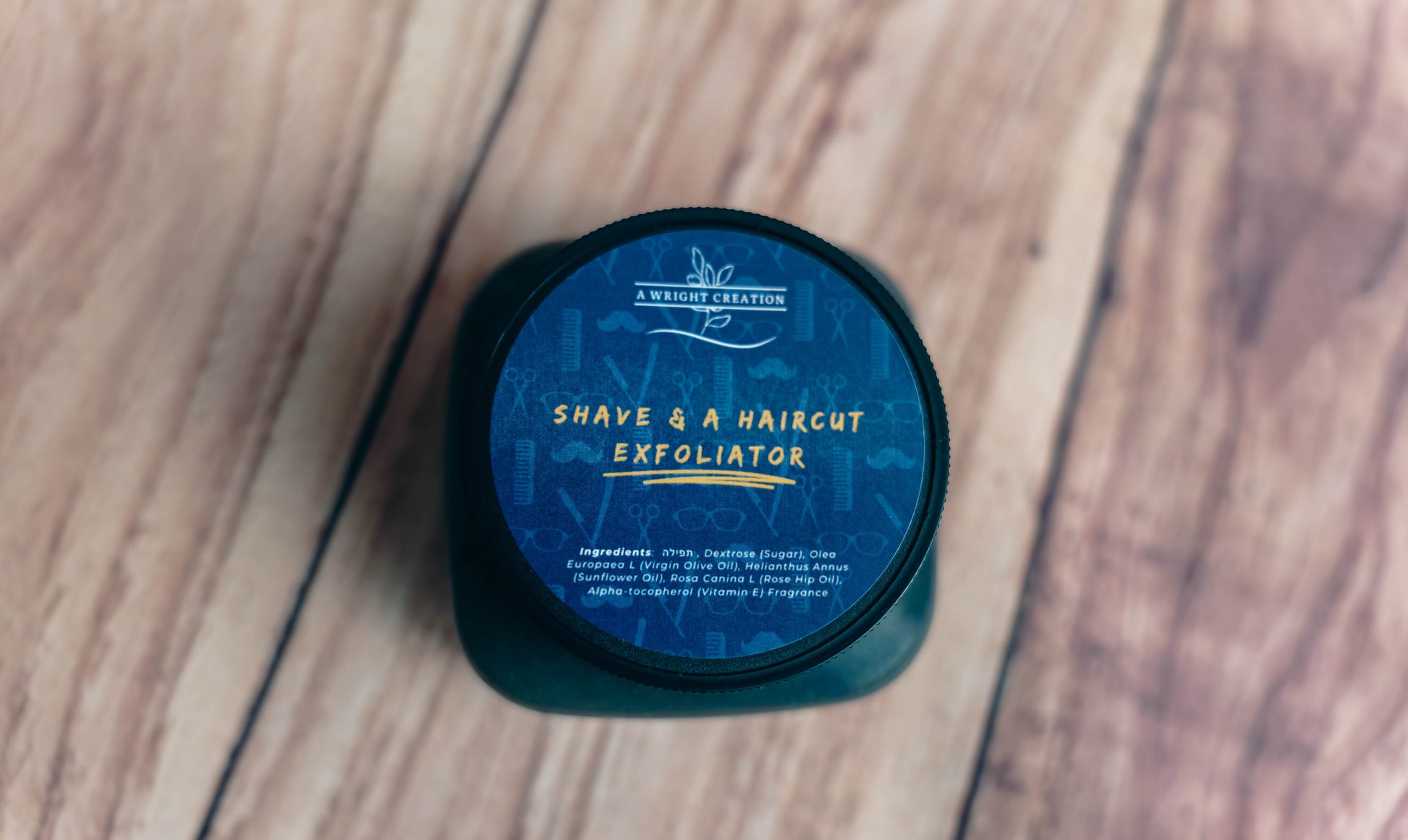 Exfoliator container labeled 'Shave & A Haircut' on a wooden surface