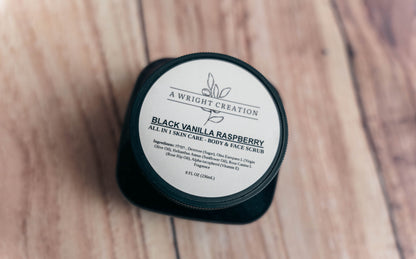 Black container of 'Black Vanilla Raspberry' scrub on a wooden surface
