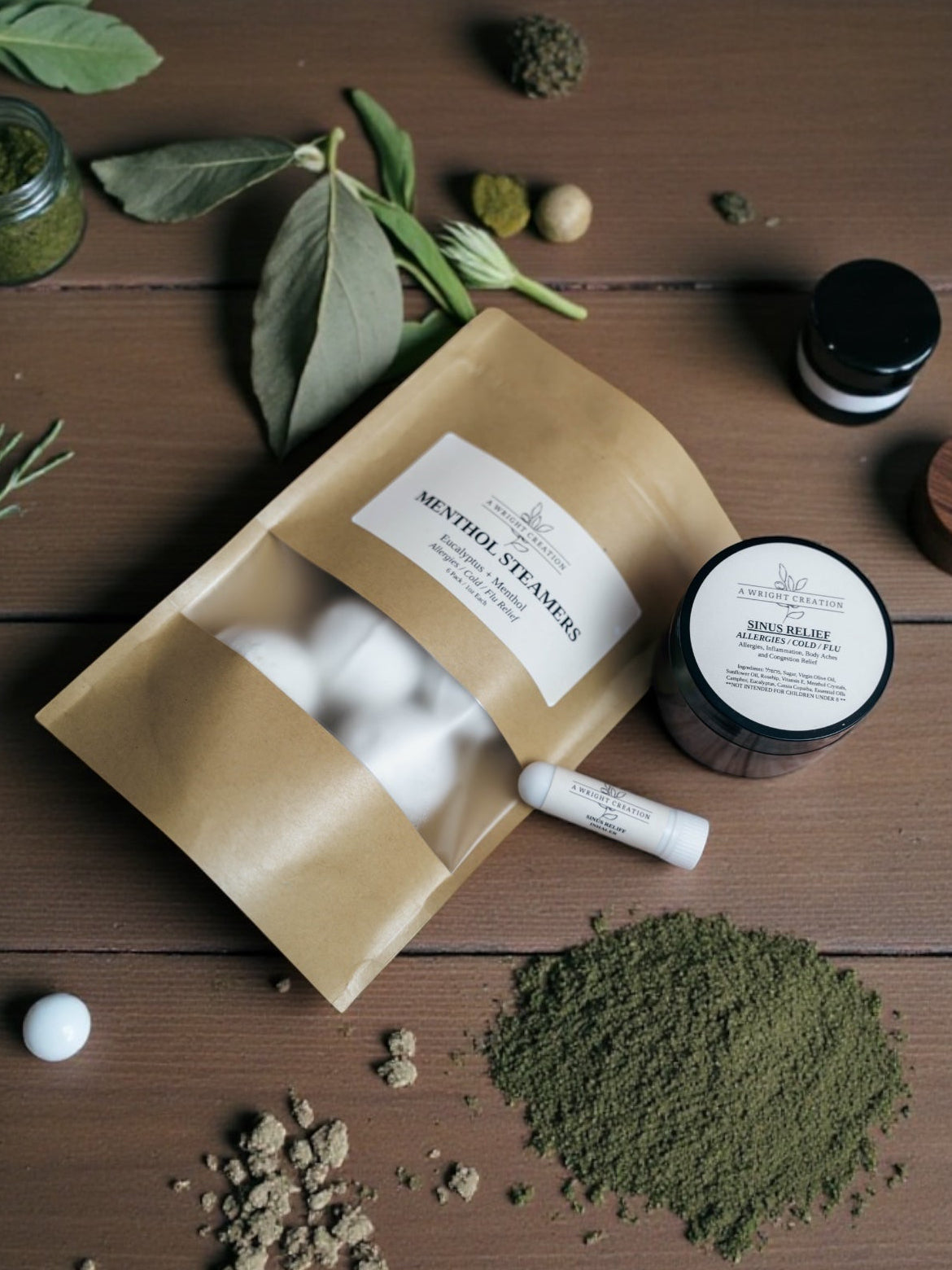 Herbal products including a brown paper bag, jar, and container on a wooden surface with green leaves.