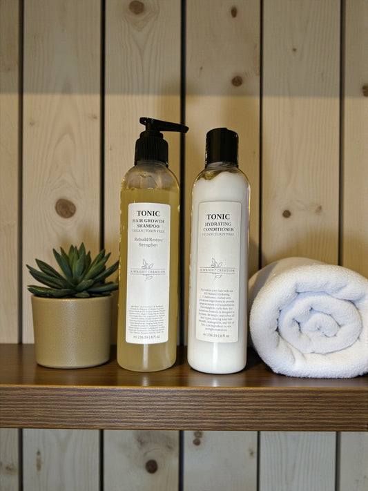 Two bottles of Tonic hair products on a wooden shelf with a plant and towel in the background.